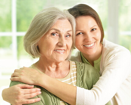 Adult daughter hugging older mom